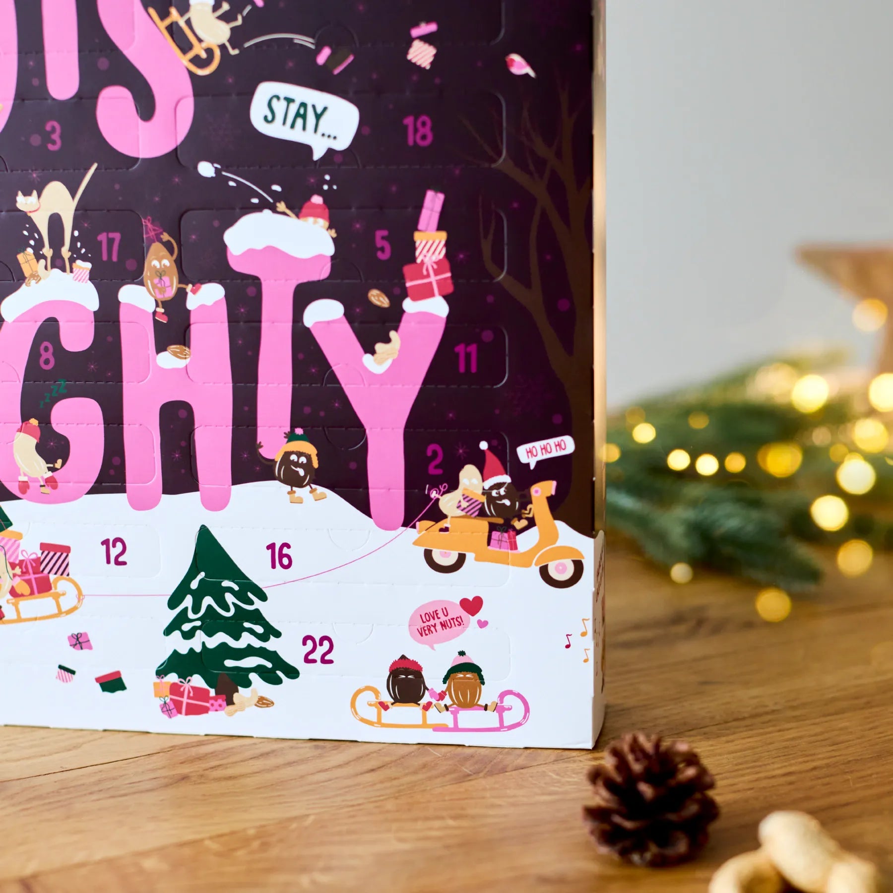 Adventskalender Classic 2026 mit weihnachtlichen Illustrationen auf einem Holztisch