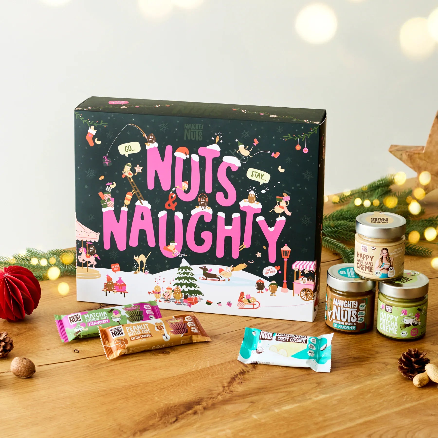 Adventskalender Deluxe 2026 mit Nussmusgläsern und Riegeln auf einem Holztisch