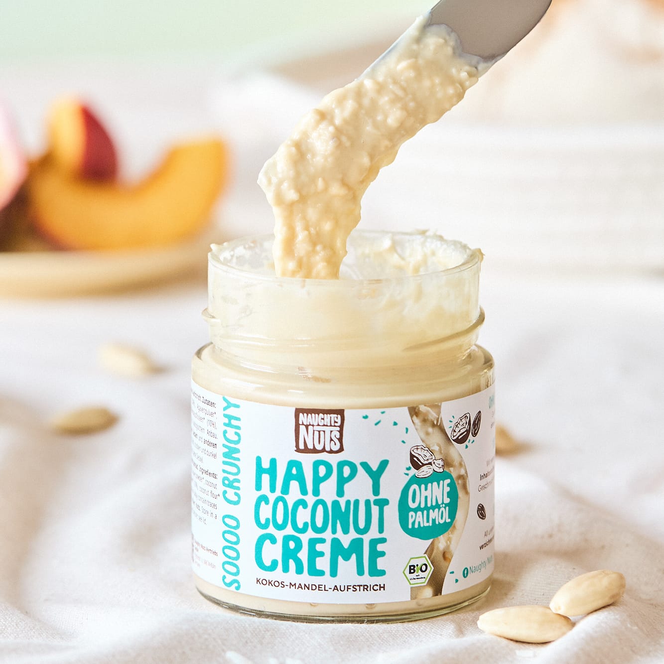 Happy Coconut Creme in einem Glas mit einem Messer, das Creme heraushebt